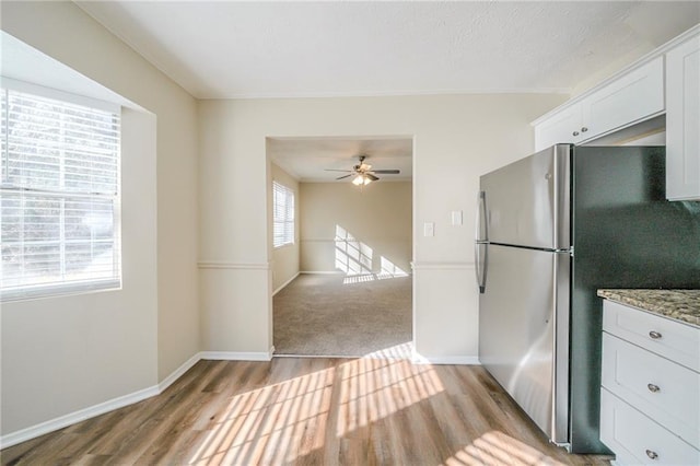 1129 Winston Dr, Decatur, GA 30032 - kitchen with light stone countertops, white cabinets, stainless steel fridge, and light hardwood / wood-style floors