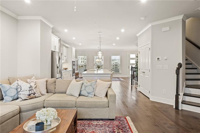 living area featuring ornamental molding, dark wood-type flooring, and stairway