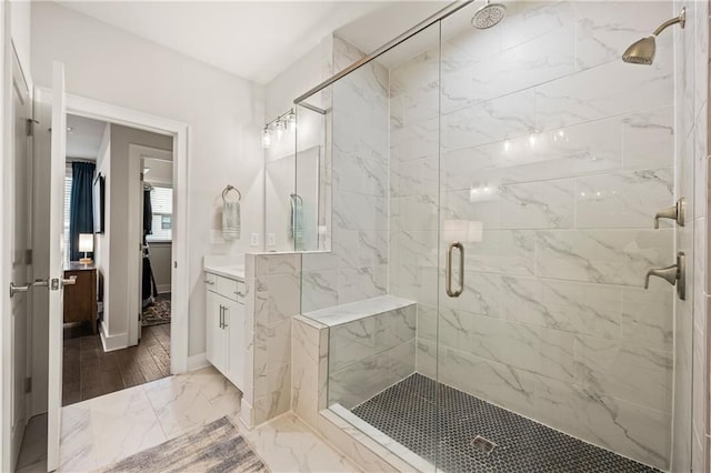 full bath featuring a stall shower, marble finish floor, vanity, and baseboards