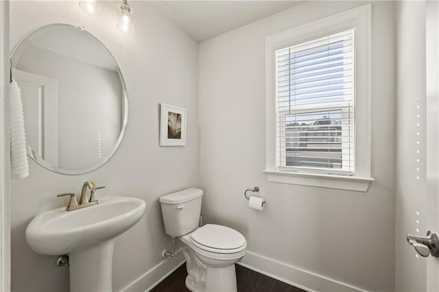 bathroom with wood finished floors, toilet, and baseboards