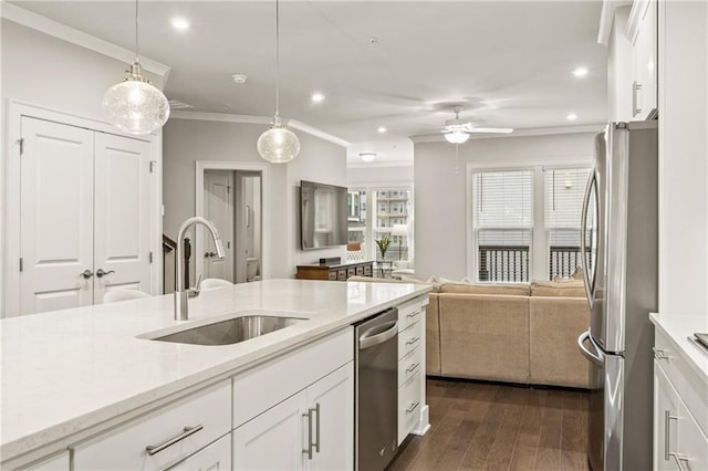 kitchen with white cabinetry, open floor plan, light countertops, appliances with stainless steel finishes, and decorative light fixtures