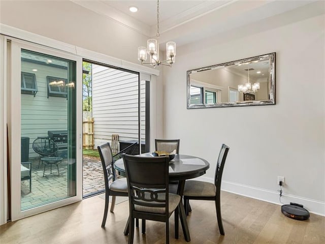 dining space featuring a notable chandelier, a raised ceiling, and hardwood / wood-style flooring