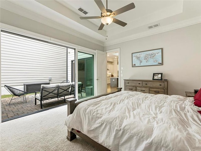 bedroom featuring ceiling fan, access to exterior, carpet flooring, and a tray ceiling