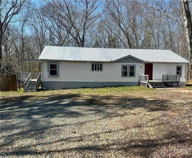 view of front of house featuring a wooden deck and metal roof