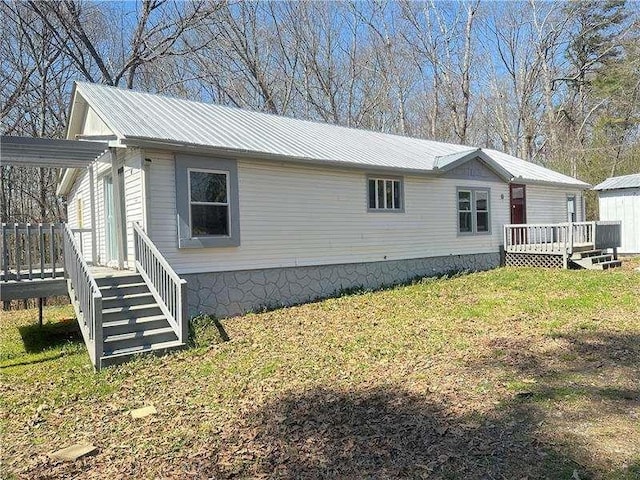 view of side of property with metal roof, a lawn, a deck, and stairway