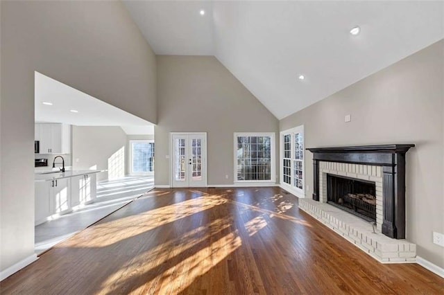3017 Lana Ln, Marietta, GA 30066 - unfurnished living room with high vaulted ceiling, wood finished floors, french doors, a fireplace, and baseboards