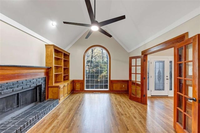 3017 Lana Ln, Marietta, GA 30066 - unfurnished living room featuring french doors, a ceiling fan, light wood-type flooring, a wainscoted wall, and a fireplace