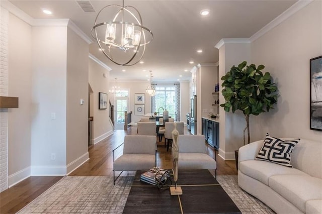 living room featuring an inviting chandelier, dark hardwood / wood-style flooring, and ornamental molding