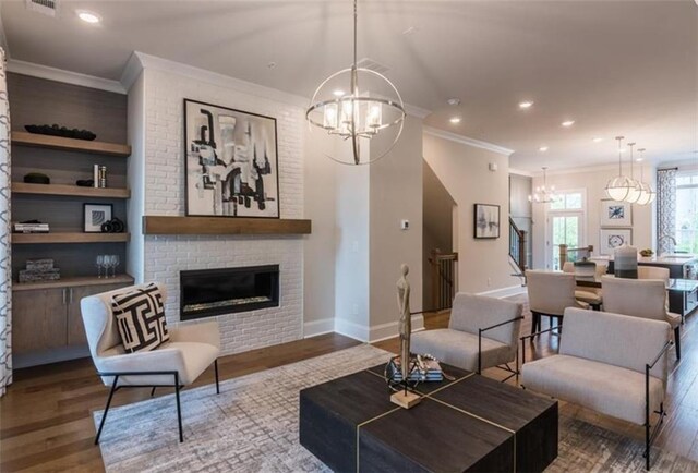 living room with a chandelier, a fireplace, dark hardwood / wood-style floors, and crown molding