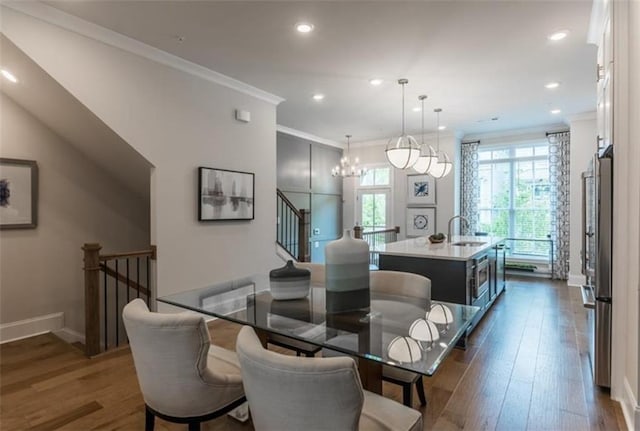 dining room with dark hardwood / wood-style floors, a chandelier, ornamental molding, and sink