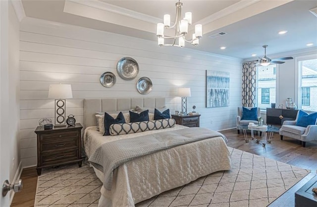 bedroom featuring ornamental molding, wood-type flooring, wood walls, and a notable chandelier