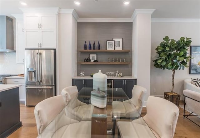 dining area featuring ornamental molding and light hardwood / wood-style flooring