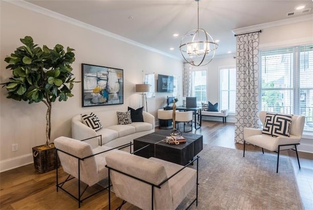 living room with crown molding, a chandelier, and hardwood / wood-style flooring