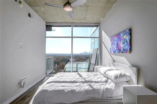 bedroom featuring wood finished floors, a wall of windows, baseboards, and ceiling fan