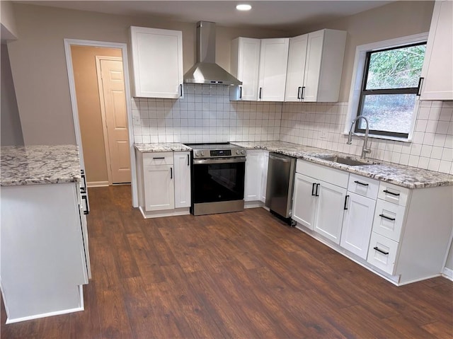 kitchen featuring wall chimney exhaust hood, sink, dark hardwood / wood-style flooring, stainless steel appliances, and white cabinets