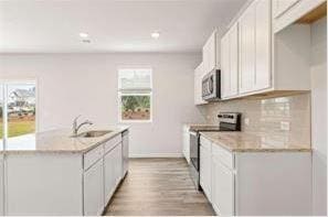 kitchen with stainless steel appliances, plenty of natural light, and white cabinets