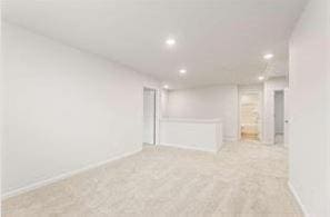 unfurnished room featuring light carpet