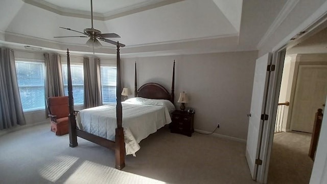 bedroom with ceiling fan, ornamental molding, light carpet, and a tray ceiling