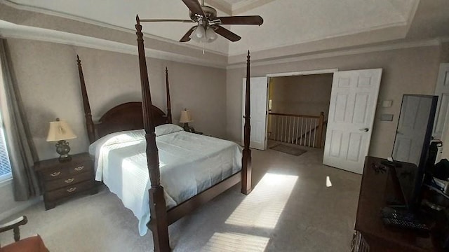 bedroom with a raised ceiling, ceiling fan, carpet flooring, and ornamental molding