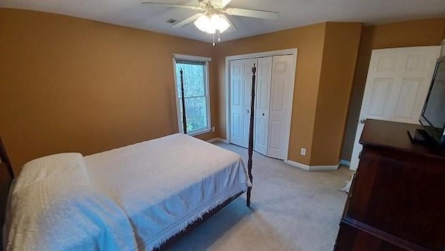 bedroom featuring ceiling fan, a closet, and light colored carpet