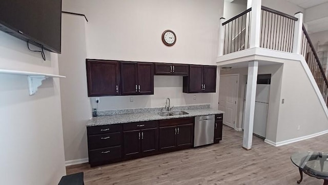 kitchen with stainless steel dishwasher, white refrigerator, a towering ceiling, light hardwood / wood-style floors, and dark brown cabinets