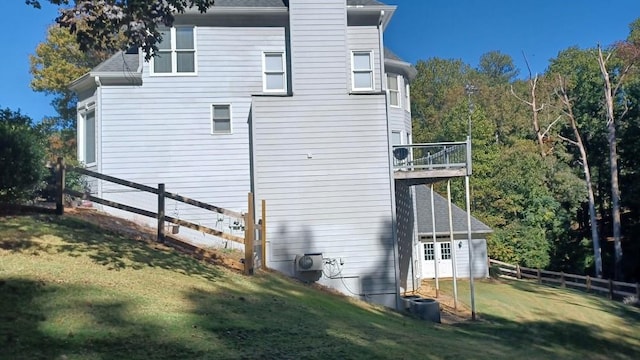 view of side of property featuring a yard and a balcony