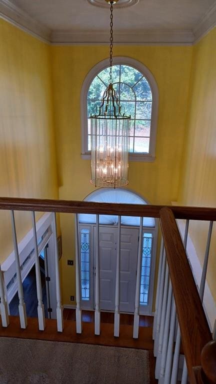 foyer entrance featuring ornamental molding and an inviting chandelier