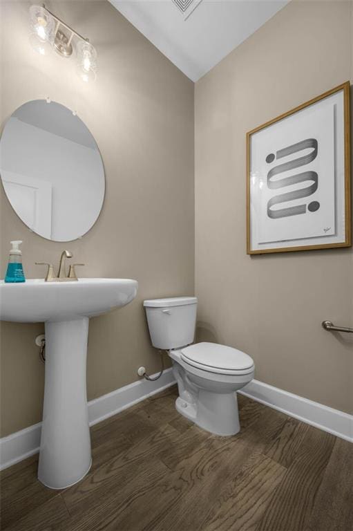 bathroom featuring hardwood / wood-style flooring and toilet