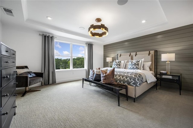 bedroom featuring a tray ceiling, wood walls, and carpet flooring