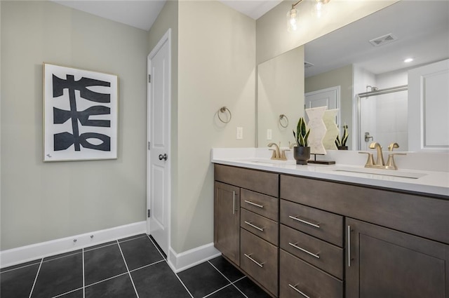 bathroom featuring a shower with shower door, vanity, and tile patterned flooring