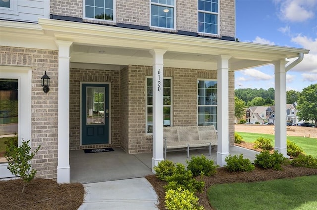 view of exterior entry featuring covered porch