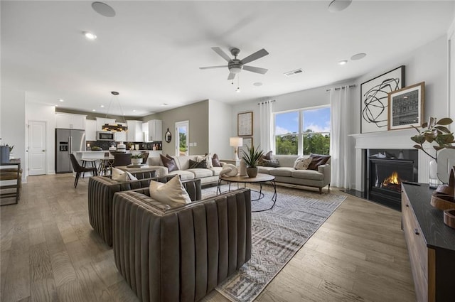 living room with ceiling fan and hardwood / wood-style floors