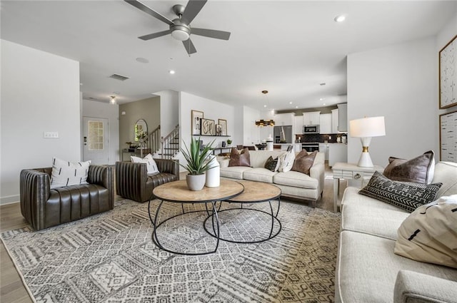 living room with ceiling fan and light hardwood / wood-style flooring