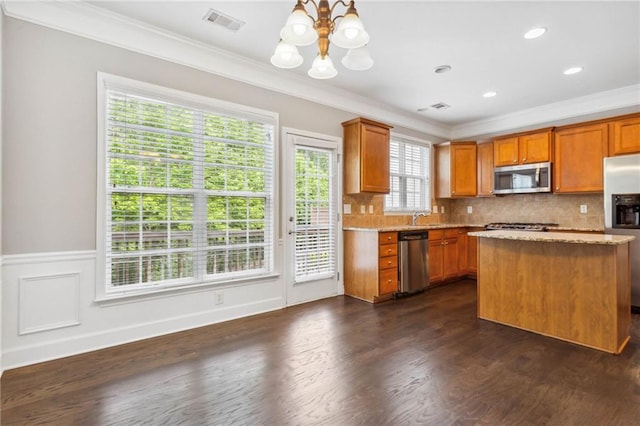 2252 Limehurst Dr NE, Atlanta, GA 30319 - kitchen featuring appliances with stainless steel finishes, ornamental molding, a chandelier, a kitchen island, and dark wood-type flooring