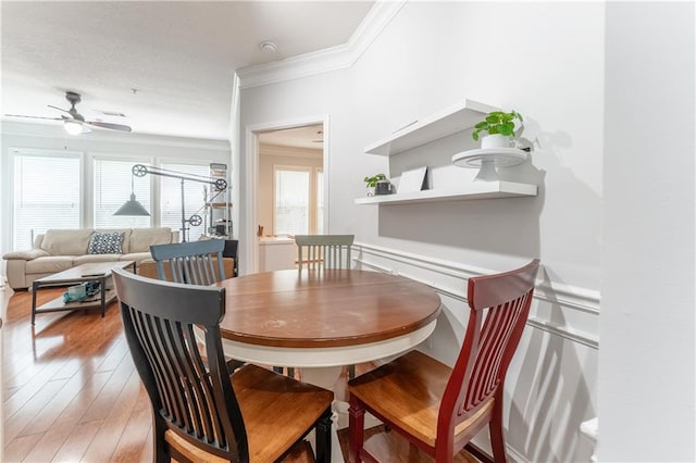dining space with ceiling fan, light wood-style floors, and crown molding
