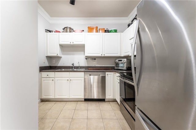 kitchen featuring white cabinets, ornamental molding, stainless steel appliances, a sink, and light tile patterned floors