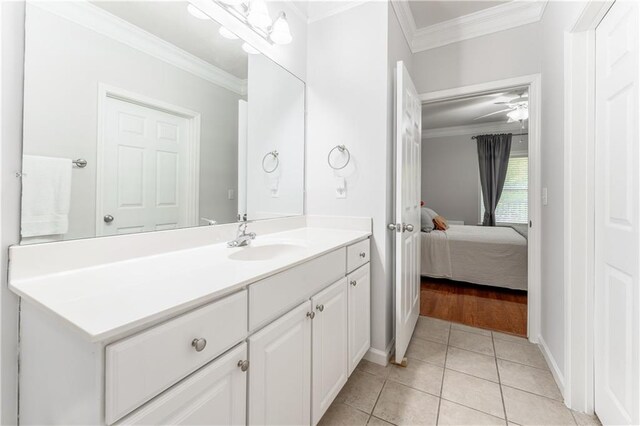 bathroom with tile patterned flooring, ceiling fan, vanity, and crown molding