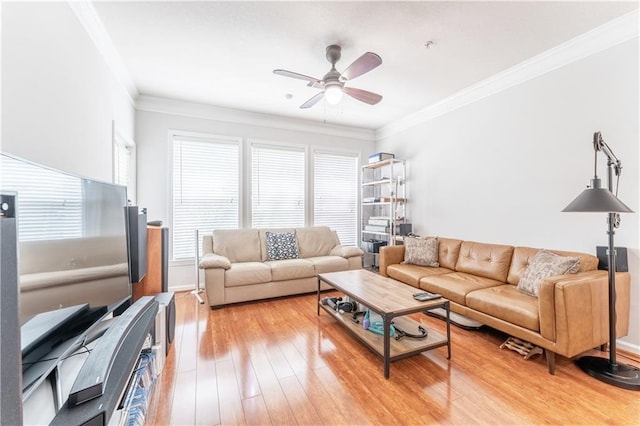 living area featuring light wood-style floors, ornamental molding, and a ceiling fan