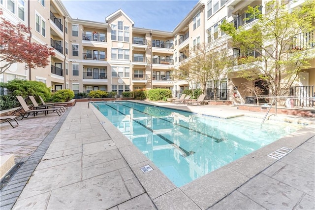 community pool with a patio and a community hot tub