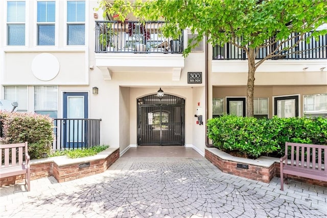 entrance to property featuring stucco siding and a gate