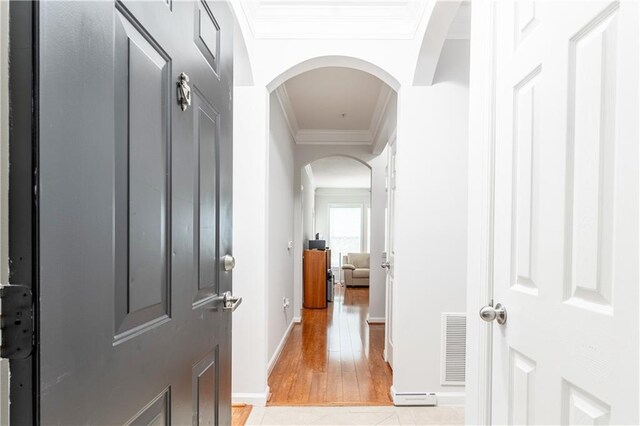 corridor featuring ornamental molding and light hardwood / wood-style floors