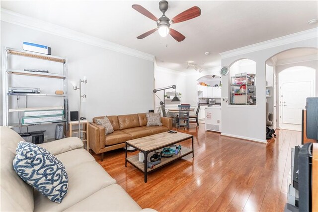 living room with ceiling fan, crown molding, and hardwood / wood-style floors