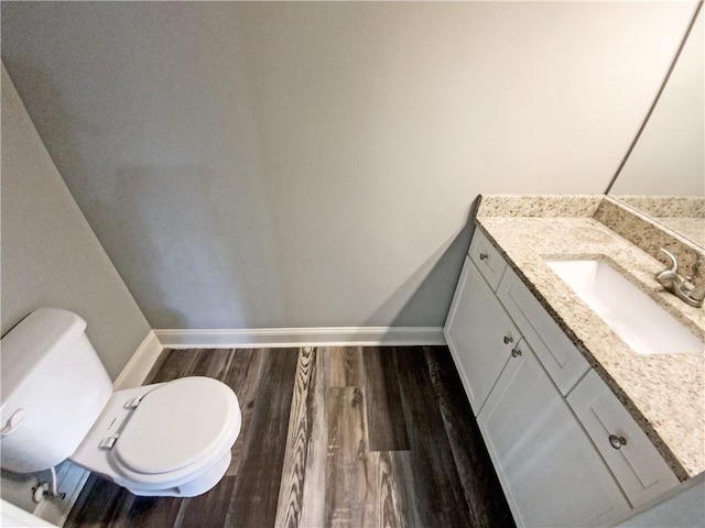 bathroom featuring vanity, hardwood / wood-style flooring, and toilet