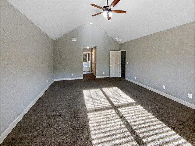 interior space featuring ceiling fan, dark carpet, and lofted ceiling