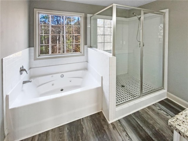 bathroom featuring wood-type flooring and shower with separate bathtub