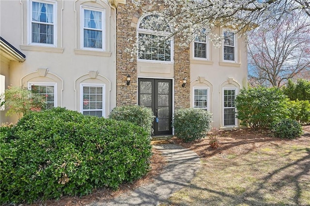 doorway to property with stone siding and stucco siding