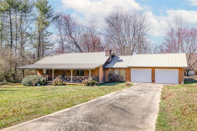 ranch-style home featuring covered porch, a front yard, and a garage