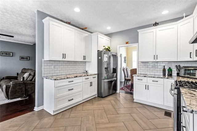 kitchen featuring a textured ceiling, stainless steel appliances, and white cabinets