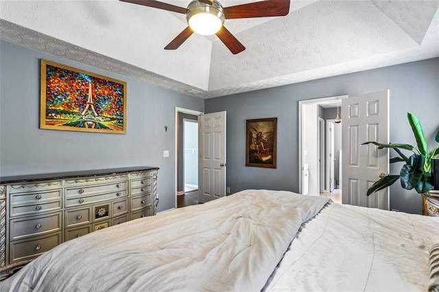 bedroom featuring vaulted ceiling, a textured ceiling, and ceiling fan