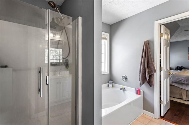 bathroom featuring a garden tub, connected bathroom, a textured ceiling, and a stall shower